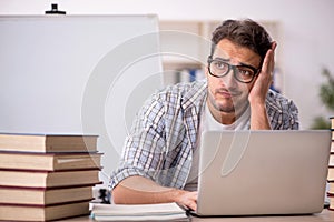 Young male student preparing for exams in the classroom