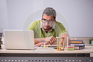 Young male student preparing for exams in the classroom