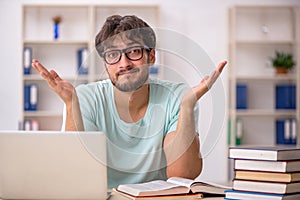 Young male student preparing for exams in the classroom