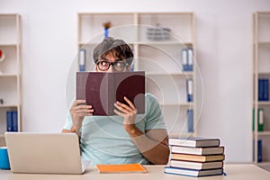 Young male student preparing for exams in the classroom