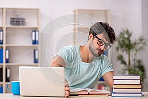 Young male student preparing for exams in the classroom