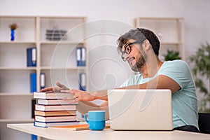 Young male student preparing for exams in the classroom