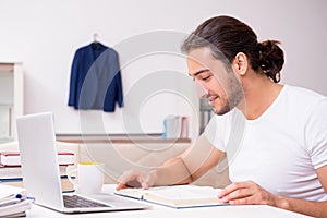 Young male student preparing for exams at home