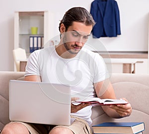 Young male student preparing for exams at home