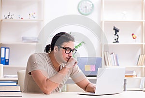 Young male student preparing for exams at home