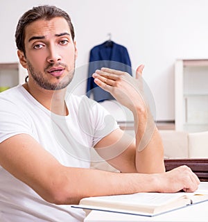 Young male student preparing for exams at home