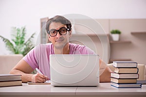 Young male student preparing for exams at home