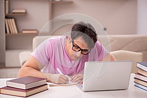 Young male student preparing for exams at home