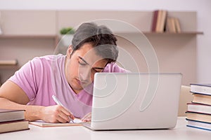 Young male student preparing for exams at home