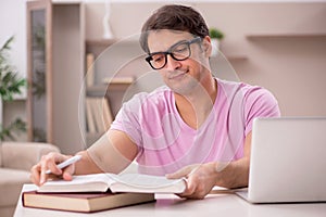 Young male student preparing for exams at home