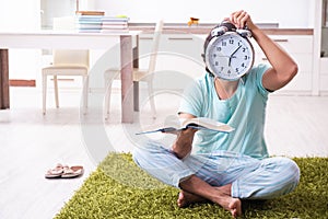 Young male student preparing for exams in time management concep