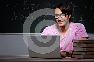 The young male student sitting in classroom