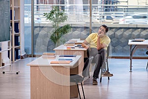 Young male student sitting in the classroom