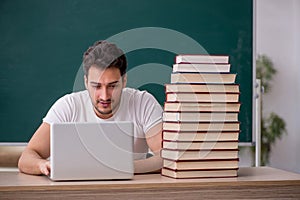 Young male student sitting in the classroom