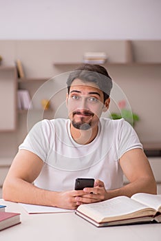 Young male student studying at home during pandemic