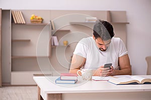 Young male student studying at home during pandemic