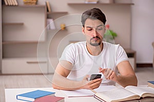 Young male student studying at home during pandemic