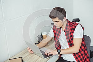 young male student using laptop