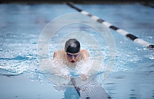 Young male swimmer swims the breaststroke in a competition