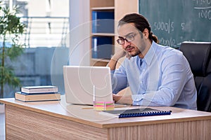 Young male teacher in the classroom