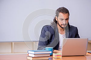 Young male teacher in the classroom