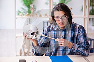 Young male teacher paleontologist in the classroom