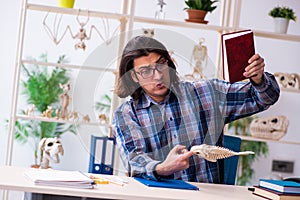 Young male teacher paleontologist in the classroom