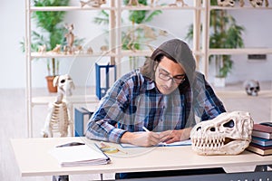 Young male teacher paleontologist in the classroom