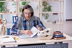 Young male teacher paleontologist in the classroom