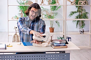 Young male teacher paleontologist in the classroom