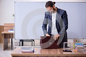 Young male teacher physicist in the classroom