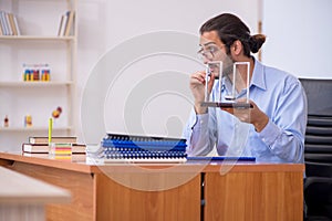 Young male teacher physicist in the classroom