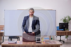 Young male teacher physicist in the classroom