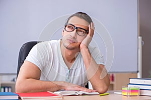 Young male teacher student sitting in the classroom