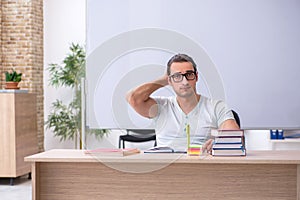 Young male teacher student sitting in the classroom