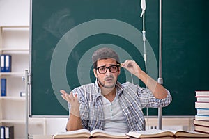 Young male teacher suffering in the classroom