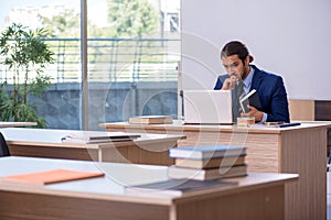 Young male teacher in suit in the classroom