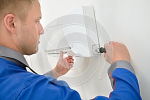 Young Male Technician Repairing Air Conditioner