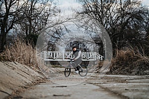 Young male teenager enjoying a bike ride in a serene park setting