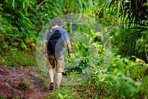 Young male tourist hiking on the famous Kalalau trail along Na Pali coast of the island of Kauai