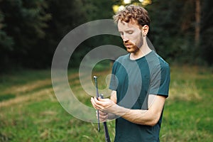 A young male tourist set up a tent in the forest