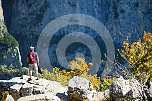 Young male tourist at Vikos Gorge, a gorge in the Pindus Mountains of northern Greece, lying on the southern slopes of Mount Tymfi