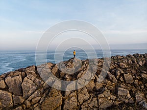 Giovane maschio turista giacca piedi sul roccioso Oceano scogliera Costa 