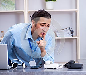 Young male travel agent working in the office