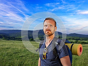 Young male traveler with a backpack in a landscape.