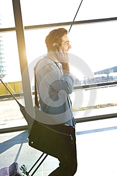 Young male traveler walking with bags at airport