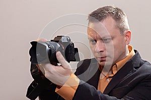 Young male video cameraman, photographer, shoots video or takes a photo on the camera