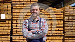 Young male worker in timber lumber warehouse