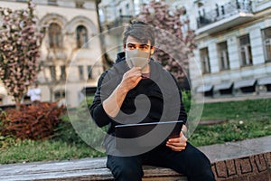 Young male working on his laptop computer in the city center. An independent person typing something in his document. chatting