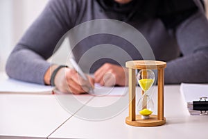 Young male writer in time management concept